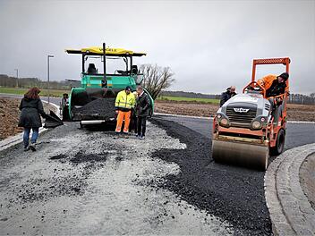 Die Firma Günther-Bau bringt gegenwärtig die Asphaltschichten ein. Mit der neuen Siedlungsstraße "Weidenleite" werden 27 Baugrundstücke erschlossen. Foto: Werner Reißaus
