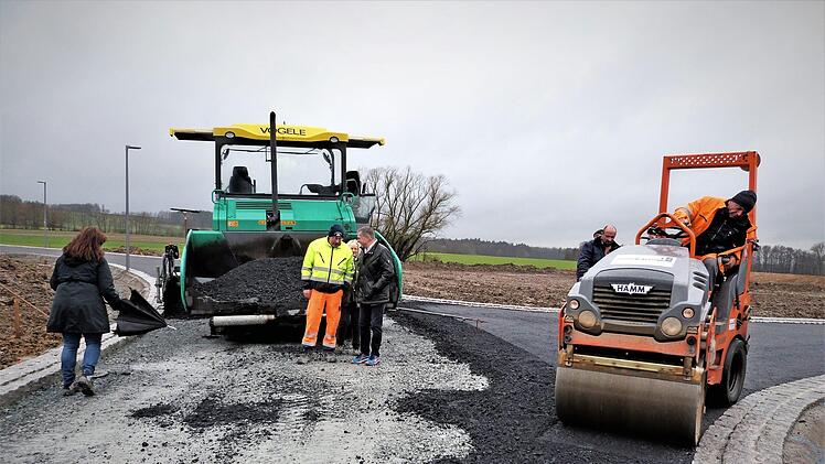 Die Firma Günther-Bau bringt gegenwärtig die Asphaltschichten ein. Mit der neuen Siedlungsstraße "Weidenleite" werden 27 Baugrundstücke erschlossen. Foto: Werner Reißaus