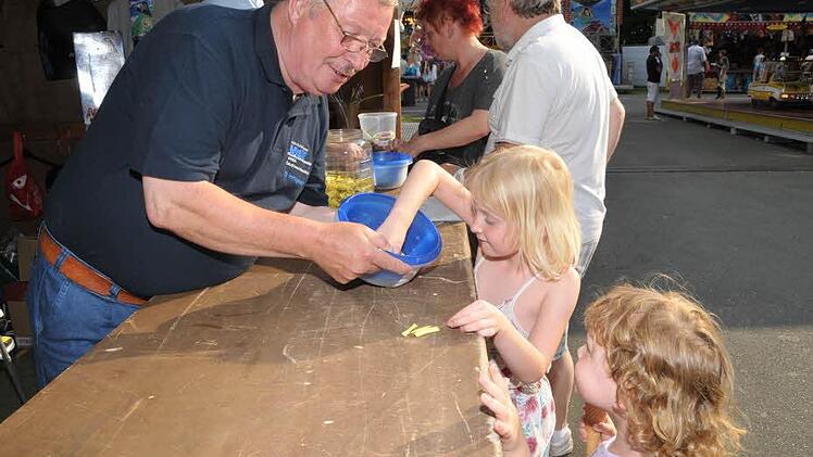 Sara (Mitte) und Lea kaufen Lose bei Georg Peetz und hoffen natürlich auf den Hauptgewinn. Foto: Roland Meister
