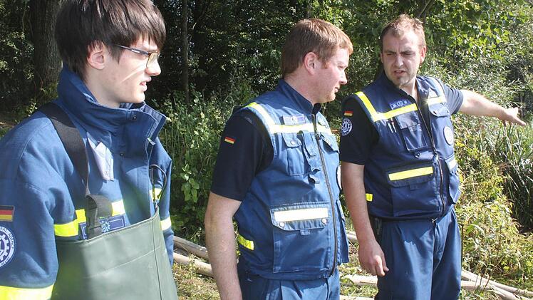 Johannes Stich (rechts) hat die Einsatzleitung beim THW. Hier erklärt er Erik Trebes (links) und Benedikt Spörl, wo eine weitere Pumpe eingesetzt werden soll. Foto: Matthias Einwag