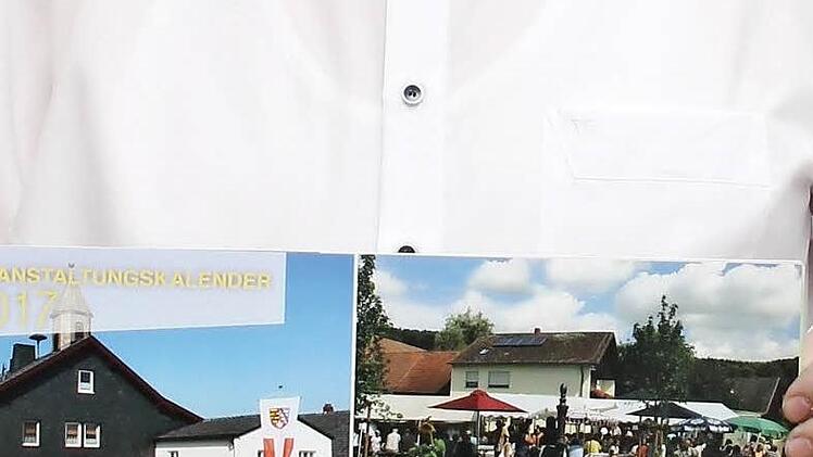 Stolz pr&auml;sentiert der 2. B&uuml;rgermeister der Gemeinde Schneckenlohe, Andreas Kristek, den Kalender 2017 "Das Gemeindeleben in Bildern". Foto: Herbert Fischer