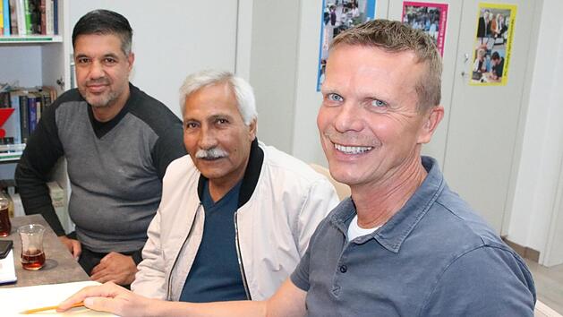 Georg Panzer (rechts) trifft sich jede Woche mit Fl&uuml;chtlingen und Helfern zum Sprach-Caf&eacute;, gestern sa&szlig;en unter anderem (von links) Karim Ghafuri und Golahmad Bayat mit am Tisch, um etwas &uuml;ber die deutsche Geschichte zu erfahren. Foto: Ralf Ruppert