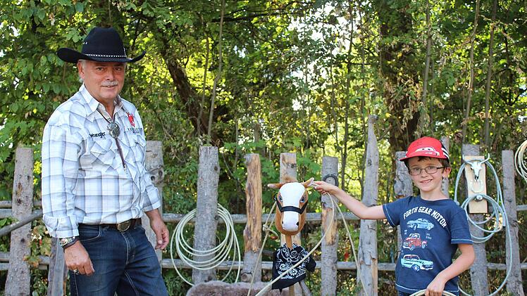 Der sechsjährige Emilio aus Schweinfurt besucht gemeinsam mit seinen Eltern das Countryfestival. Gerhard Langner zeigt ihm, wie man richtig mit dem Lasso umgeht. Foto: Cindy Dötschel