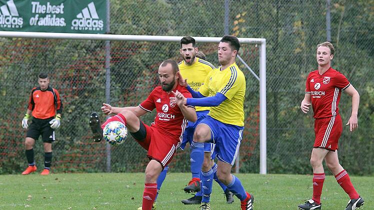 Der Buttenheimer Stefan Kramer (rotes Trikot) versucht, den Ball gegen die Mitwitzer Janko Wei&szlig; (rechts) und Marc Hofmann zu behaupten.  Foto: Sportpress