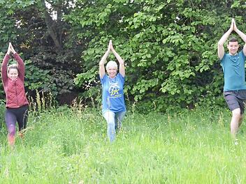 Die Frische der Natur genießen und mit Freude Waldyoga üben: Birgit Schmitt (Mitte) vom Verein "Gemeinsam gegen Krebs" zeigte mit Patricia Hurec und Camil Hurec auf einem Waldparcours einige Trainingsformationen. Angeboten werden Kraft- und Atemübungen, aber auch Klangschalenmeditation.  Foto: Karl-Heinz Hofmann