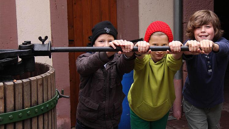 (V.l.): Moritz, Noah und Felix am langen Hebel der Kelter.