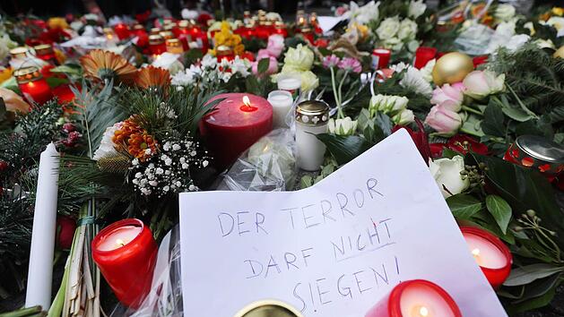 Kerzen und Blumen liegen in Berlin am Ort des m&ouml;glichen Anschlags. Dem Motto auf dem Zettel folgen auch die Kronacher. Foto: Michael Kappeler/dpa