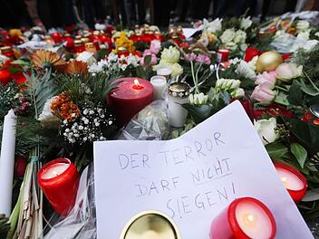 Kerzen und Blumen liegen in Berlin am Ort des möglichen Anschlags. Dem Motto auf dem Zettel folgen auch die Kronacher. Foto: Michael Kappeler/dpa