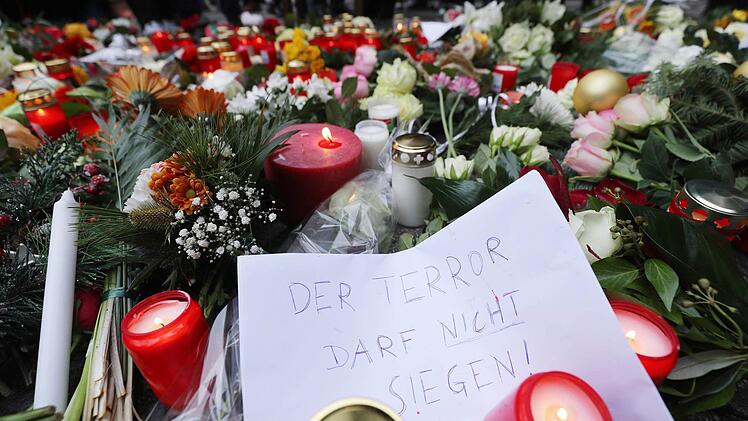 Kerzen und Blumen liegen in Berlin am Ort des möglichen Anschlags. Dem Motto auf dem Zettel folgen auch die Kronacher. Foto: Michael Kappeler/dpa