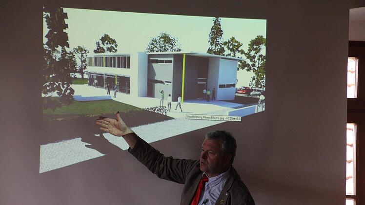 Eberns Bürgermeister zeigt ein Bild vom geplanten Neubau für die Mittagsbetreuung. Fotos: Helmut Will