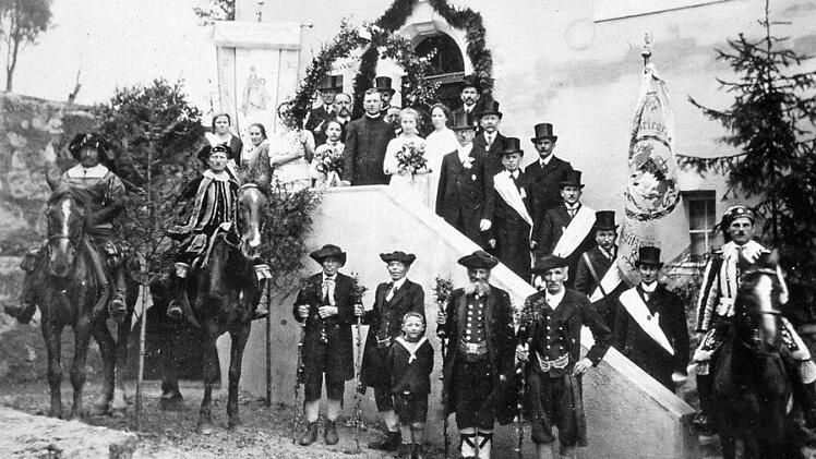 Die vier Männer in historischer Tracht, geführt von drei Reitern in mittelalterlicher Landsknechtstracht holten den Kuratus H. Hofmann (Bildmitte oben) vom drei Kilometer entfernten Waischenfeld ab und brachten ihn in sein neues Heim. Danach stellte man sich zum Gruppenbild vor das neue "Kuratenhaus".  Repro: Reinhard Löwisch