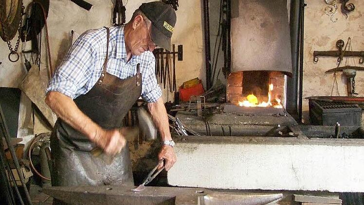 Willi Gruschke lässt den Hammer auf das rotglühende Eisen sausen.   Fotos: Berthold