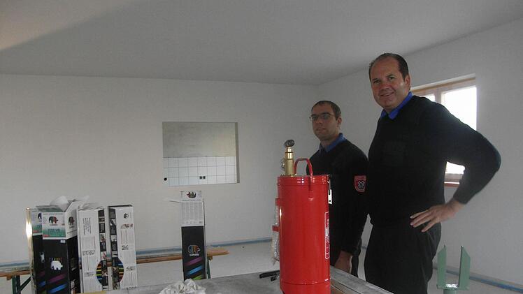 Der Kommandant der Stangenrother Freiwilligen Feuerwehr Sebastian Metz (links) und Vorsitzender Lorenz Höchemer freuen sich. Das Feuerwehrauto der engagierten Floriansjünger ist nagelneu, ebenso wie das Feuerwehrgerätehaus. Foto: Joachim Rübel