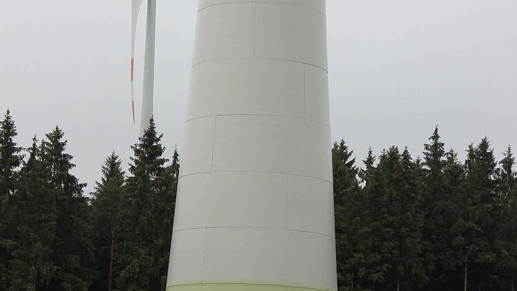 Der Turm eines Windrads besteht im unteren Bereich aus 22 Betonringen, die wiederum aus zwei bzw. drei Teilen zusammengefügt werden. Die Fugen zwischen den Beton-Einzelteilen dieses Windrads bei Münchberg sind gut zu erkennen. Der elfte Ring ist rot markiert. Ähnliche Dimensionen sollen auch die Hainer Windräder haben. Die Bäume neben dem Windrad sehen aus wie Streichhölzer.  Foto: Friedwald Schedel