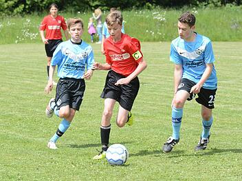 Auf dem Weg zum 2:2: Tim Weimann von der JFG Sinntal-Schondratal hat die goldene Mitte gewählt gegen Maximilian Stengler (links) und Kevin Myers vom Würzburger FV. Foto: ssp