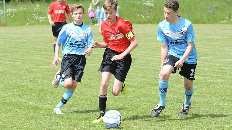 Auf dem Weg zum 2:2: Tim Weimann von der JFG Sinntal-Schondratal hat die goldene Mitte gewählt gegen Maximilian Stengler (links) und Kevin Myers vom Würzburger FV. Foto: ssp