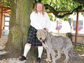 Andreas Merkel mit Kilt und Wolfshund unter der Dorflinde in Hetzles. Foto: Roepert