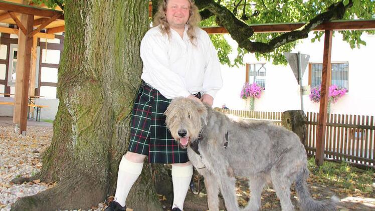 Andreas Merkel mit Kilt und Wolfshund unter der Dorflinde in Hetzles. Foto: Roepert