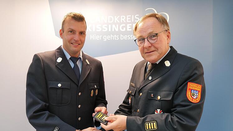 Kreisbrandrat Benno Metz (rechts) &uuml;berreicht an Markus Ullrich das Abzeichen, das ihn als Kreisbrandmeister auszeichnet.