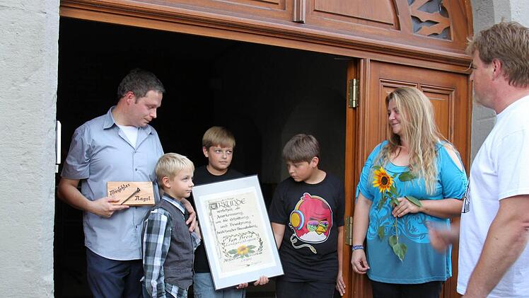 Peter Braun (r.) vom Altstadtverein Münnerstadt hat Familie Brose den Mürschter Nagel und die Urkunde übergeben. Sie haben ihr Haus aus dem Jahr 1572 zu einem richtigen Schmuckstück hergerichtet.  Fotos: Martina Straub