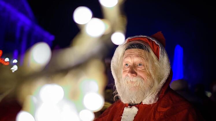 Ein als Weihnachtsmann verkleideter Freiwilliger geht nach einer Besprechung im Rahmen der Weihnachtsmannvollversammlung der Berliner Weihnachtsmannzentrale durch den Tierpark am Schloss Friedrichsfelde vorbei. Mittlerweile fehlt es in Deutschland an freiwilligen Weihnachtsmännern. Foto: Gregor Fischer/dpa