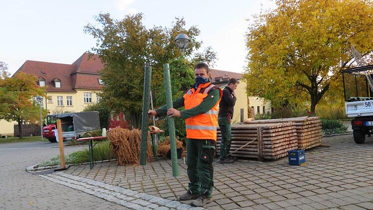 Ein Mitarbeiter händigt einen Verbissschutz aus.