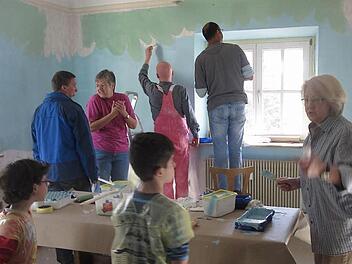 Die freiwilligen Helfer malen die Wände des Heroldsbacher Kuratenhauses an.  Foto: Pauline Lindner