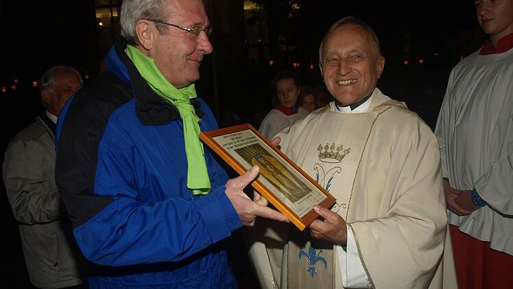 Neuer Leiter der Oerlenbacher Wallfahrt nach Retzbach ist Otmar Lutz, der im letzten Jahr zum 40. Mal dabei war und von Wallfahrtspfarrer Gerold Postler mit einem Ehrenbild ausgezeichnet wurde. Foto: Stefan Geiger