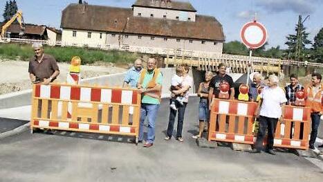 Bürgermeister Bernhard Storath (links) räumte die Baustellensperre zur Seite und gab die Unterführung für den Verkehr frei. Einige Ebensfelder Bürger hatten sich zur Freigabe der Trasse eingefunden - Beifall gab es jedoch nicht. Fotos: Matthias Einwag