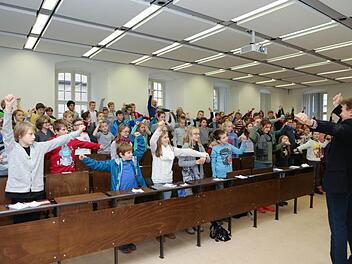Stefan Voll (rechts) streute in der Kinder-Uni-Vorlesung zum Thema Sport für die Kids auch einige Übungen ein.  Fotos: Barbara Herbst