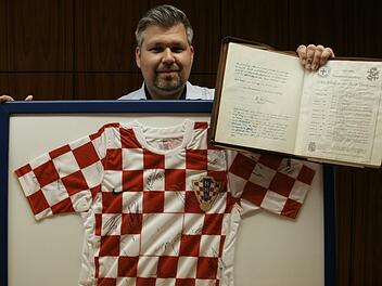 Michael Worschech von der Stadtverwaltung mit dem ersten Goldenen Buch und dem handsignierten Trikot der Kroaten von der WM 2006. Foto: Steffen Standke