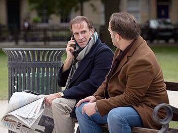 Richard Ratcliffe (Joseph Fiennes, links) bleibt mit seinem Freund Oliver Denton (Sam Troughton) hartn&auml;ckig am Ball, um von London aus mehr &uuml;ber das Schicksal seiner Familie zu erfahren.