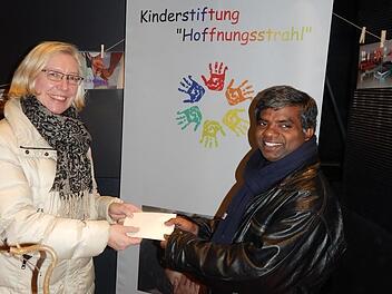 Die Spendenbox der Stiftung "Hoffnungsstrahl" bei der "Drossenfelder Weihnacht" f&uuml;llte sich mit 724,50 Euro. Diese Summe &uuml;bergab Ute Caspar-Gundel, Vorsitzende des katholischen Pfarrgemeinderats an Pater Thomas Muttan. Foto: Horst Wunner