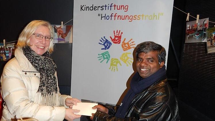 Die Spendenbox der Stiftung "Hoffnungsstrahl" bei der "Drossenfelder Weihnacht" f&uuml;llte sich mit 724,50 Euro. Diese Summe &uuml;bergab Ute Caspar-Gundel, Vorsitzende des katholischen Pfarrgemeinderats an Pater Thomas Muttan. Foto: Horst Wunner