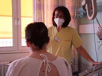 Petra Przybilla kommt zur Physiotherapie in der Akut-Früh-Reha auf das Patientenzimmer. Gerade steht Aufsteh- und Gangtraining mit Stefan Schmitt auf dem Programm.