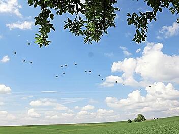 Fallschirmjäger schweben über den Feldern zwischen Adelsberg und Karsbach. Fotos: Arkadius Guzy