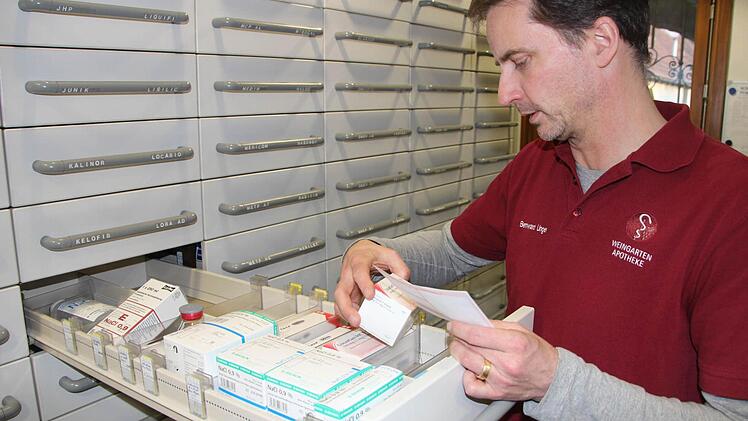 Schnelle Hilfe: Bernward Unger holt das passende Medikament aus dem großen Apothekerschrank.Foto: Ralf Dieter