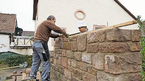 Karl-Heinz Nöth und Heiko Schärpf ziehen die Mauer hoch.