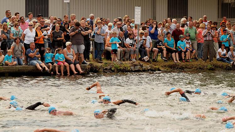 Zahlreiche Zuschauer beobachten die Positionskämpfe der Schwimmer auf der Strecke im Altmain.