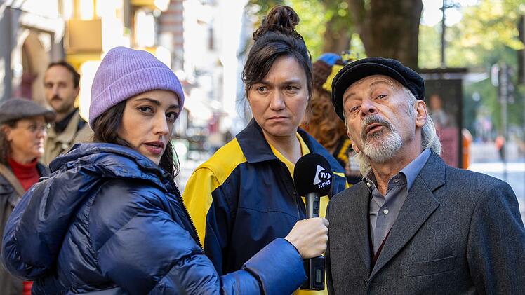 Es dauert nicht lange, da berichtet auch eine TV-Reporterin (C&eacute;line Yildirim, links) &uuml;ber die Protestaktion des Friseurs Nadim Demir (Vedat Erincin). Auch die Postbotin (Stephanie Petrowitz) unterst&uuml;tzt die Aktion.