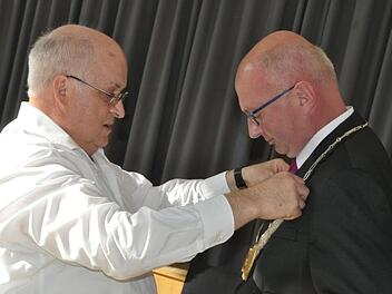 Nach der Vereidigung hängte Gemeinderat Klaus Dünisch (KUL, links) dem neuen Bürgermeister der Gemeinde Pfarrweisach, Markus Oppelt (CSU), die Bürgermeisterkette um. Simon Albrecht