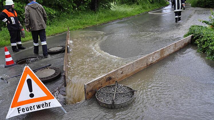 Die Feuerwehr versuchte nach Kräften, den Regen zu kanalisieren. Die Rohre unter der Straße waren überfordert. Foto: Petra Hartmann