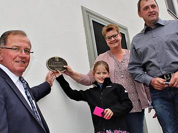 Hierhin könnte die Plakette passen. Bezirkstagspräsident Erwin Dotzel und Familie Sitzmann vor dem ausgezeichneten Haus im Hammelburger Stadtteil Pfaffenhausen.Werner Vogel