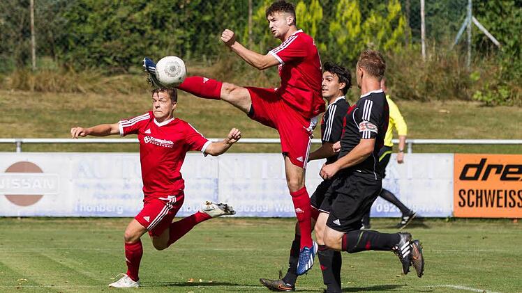 VfR Johannisthal - TSV Weißenbrunn: Gästeangreifer Philip Spindler (rotes Trikot) holt den Flankenball aus der Luft, nimmt dadurch aber Adrian Schramm die Chance zum Torschuss. Foto: Heinrich Weiß