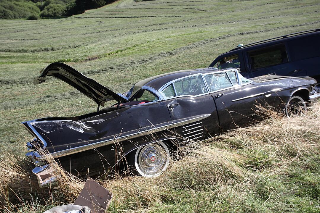 Mit Cadillac beladener Auto-Anhaenger kommt von der Fahrbahn ab