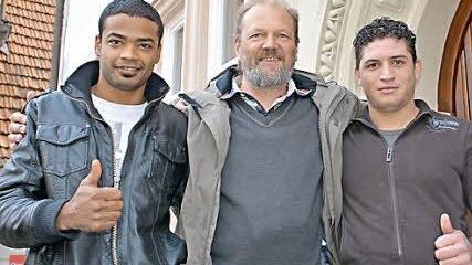 Geschafft: Die Freude darüber in Deutschland einen Asylantrag zu stellen, war sowohl Pfarrer Karl Feser als auch den beiden Syrern Saleh und Nawras, anzumerken. Vor dem Pfarrhaus in Bad Königshofen verabschiedete sie Pfarrer Karl Feser. Dem voraus gegangen waren mehrere Monate Kirchenasyl in Hammelburg und zuletzt in Bad Königshofen. Foto: Hanns Friedrich