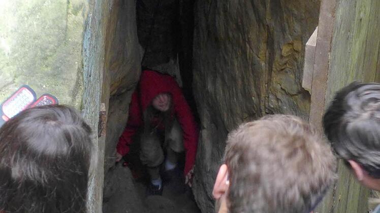 Voller Spannung werden die Höhlenbesteiger von Neugierigen erwartet. Als Erste kriecht die achtjährige Janine Schug aus Reckendorf heraus und stellt fest: "Tief und kalt ist es da unten."