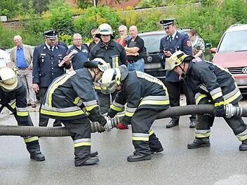 Genauigkeit, Geschicklichkeit und Schnelligkeit sind beim Ankuppeln der Saugleitung gefragt. David Haun, Christian Trebes, Rene Geiger und Dominik Hilbert (von links) kuppeln die Saugleitung, im Hintergrund beobachtet dies Gruppenführer Andre Stadelmann.  Foto: K.- H. Hofmann