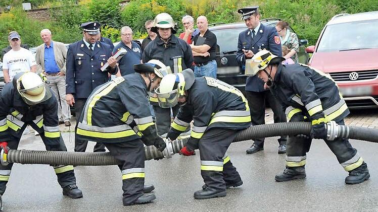 Genauigkeit, Geschicklichkeit und Schnelligkeit sind beim Ankuppeln der Saugleitung gefragt. David Haun, Christian Trebes, Rene Geiger und Dominik Hilbert (von links) kuppeln die Saugleitung, im Hintergrund beobachtet dies Gruppenführer Andre Stadelmann.  Foto: K.- H. Hofmann