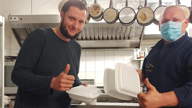 Der Disponent Thomas Auer (rechts) ist auch selbst unterwegs. Hier holt er im Restaurant Kainz "Essen auf R&auml;dern" ab.
